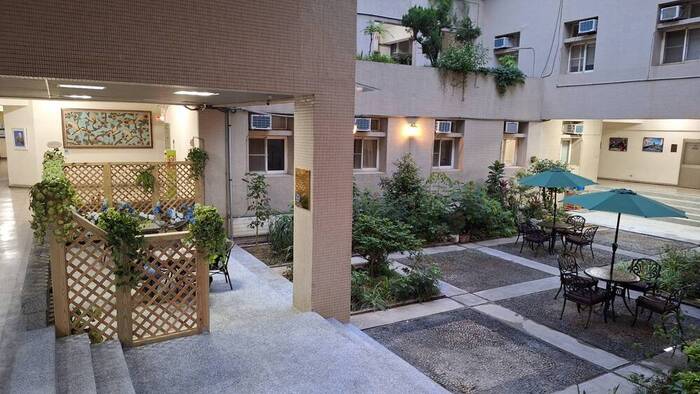 Soft lighting adorns the courtyard at night, creating a warm and tranquil landscape ambiance.